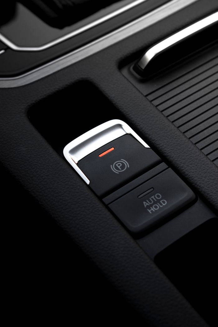 Detailed view of an electronic parking brake and auto hold button in a vehicle interior.