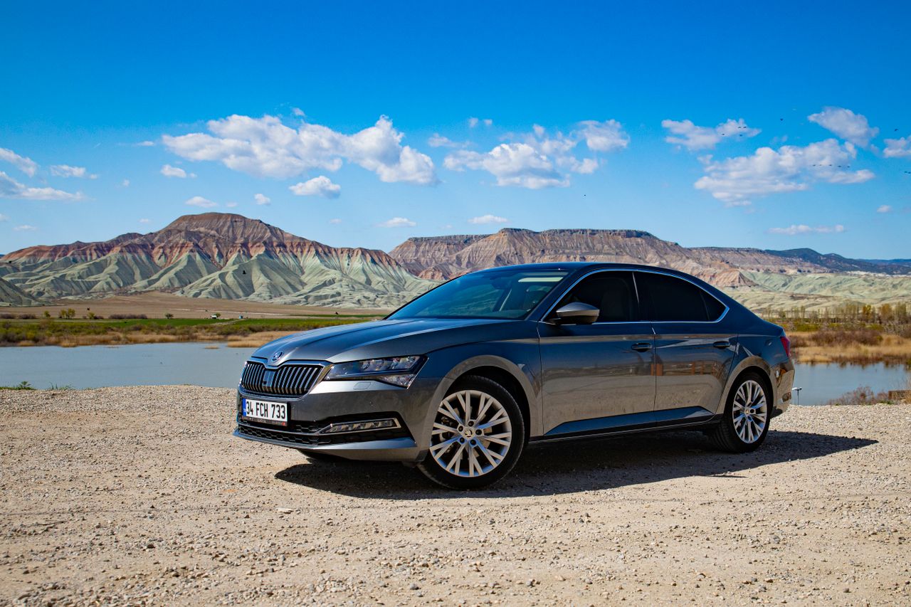 Stylish sedan parked against the stunning Nallıhan hills in Ankara, Türkiye, under a vibrant blue sky.